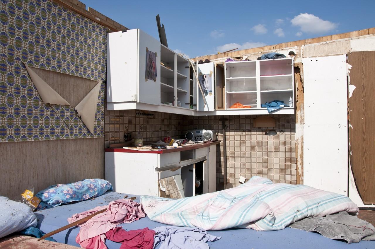 Reste eines Kleingartenhauses ohne Dach, aber mit Bett und Schränken