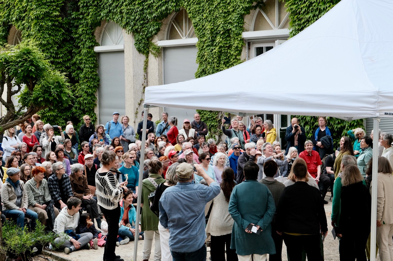 Eine Ansammlung von Menschen vor der Orangerie im Körnerpark.