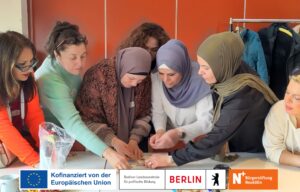 Frauen stehen um einen Tisch herum und schauen lachend und versuchen ein Puzzle zu lösen.